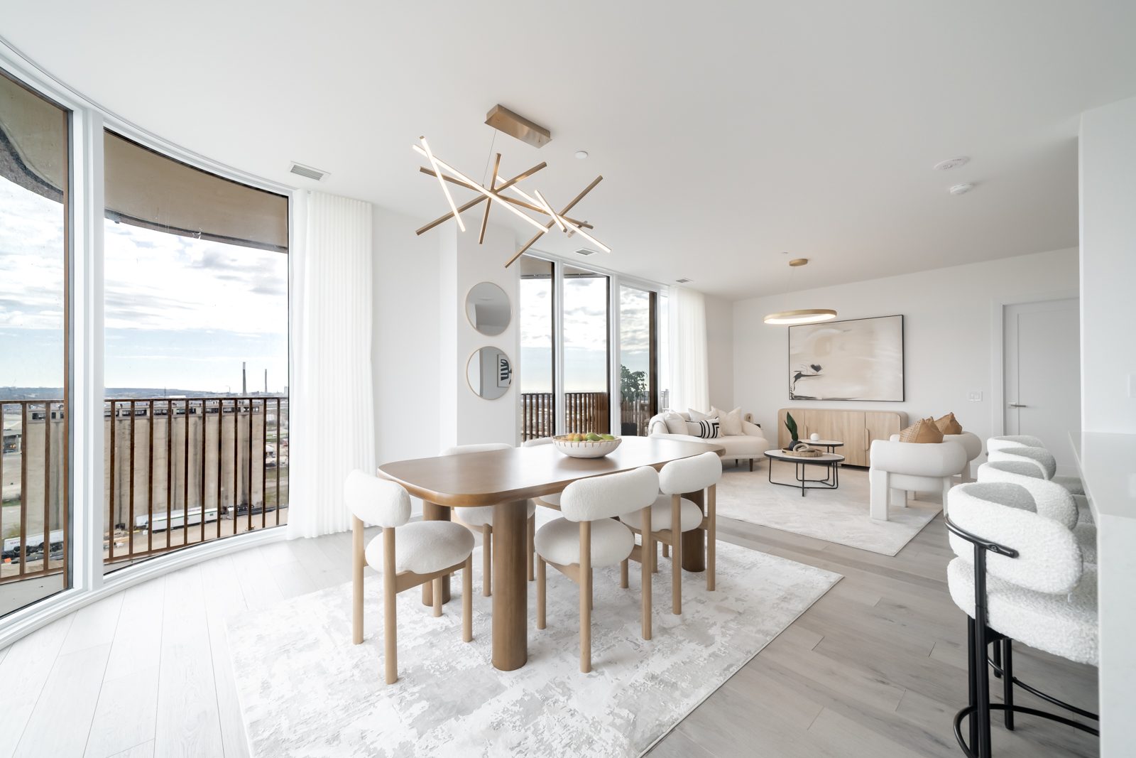 Dining area with curved floor-to-ceiling windows and a sculptural chandelier