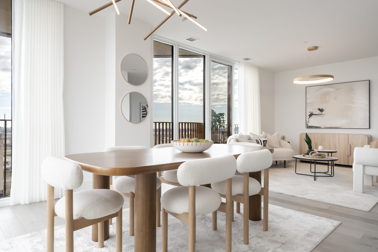 Dining table beside tall windows with a city view
