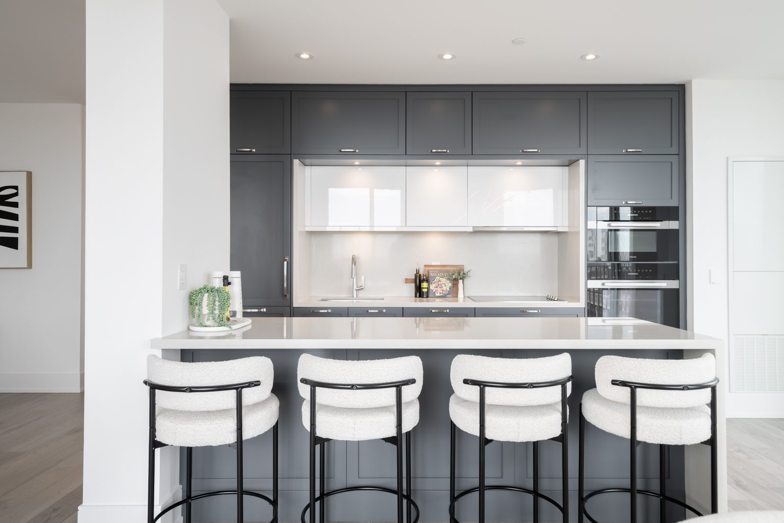 Kitchen with charcoal cabinetry and a white quartz island