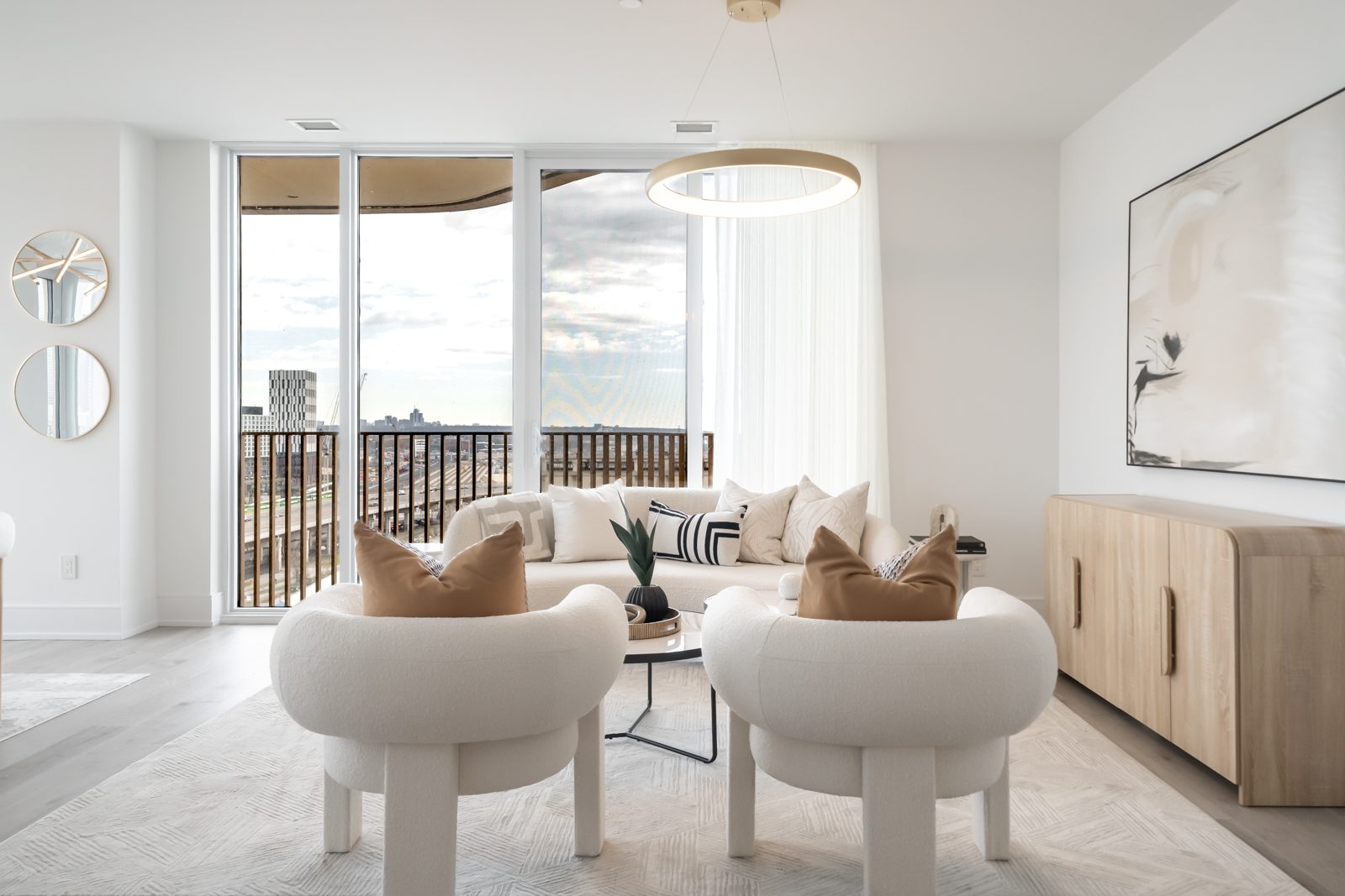 Living room with two bouclé chairs and a ring pendant light